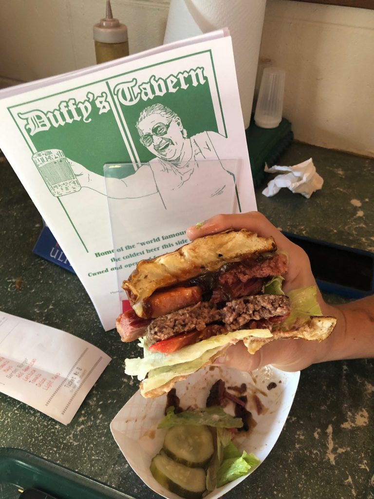 Person holding a burger at Duffy's