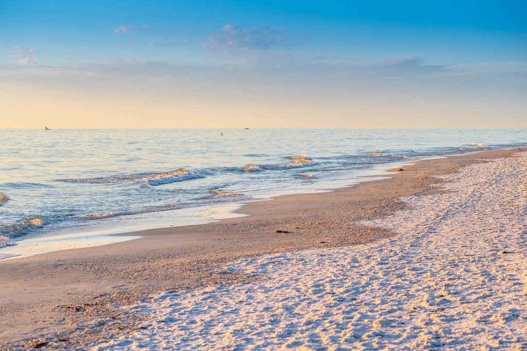 A beautiful ocean whitecap waves roll onto the sandy beach of Anna Maria Key