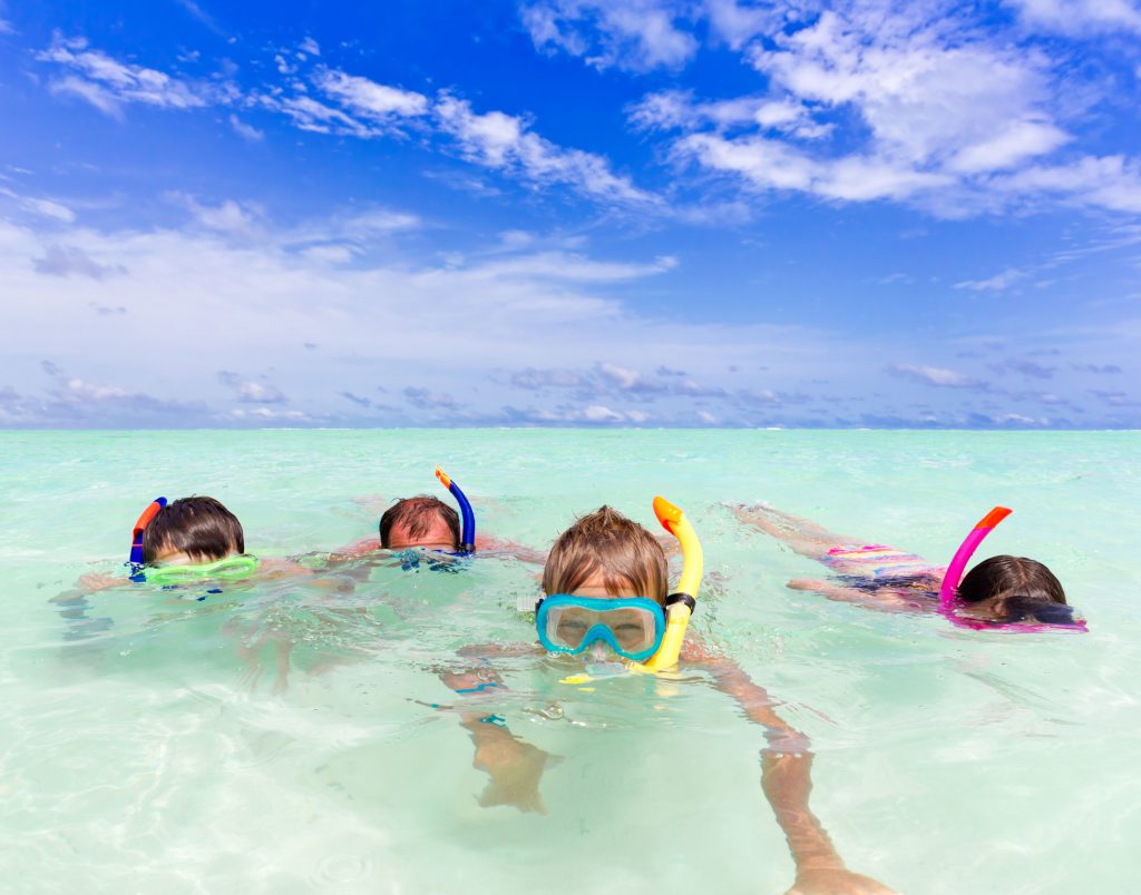 A family snorkeling in the crystal-clear water
