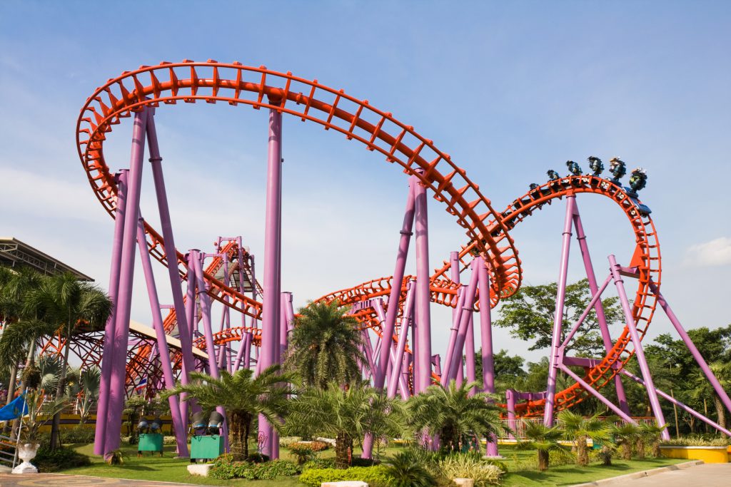 Amusement park ride purple and red with palm trees 