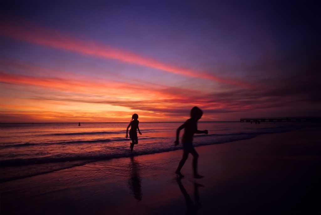 two happy children, running on the beach at sunset on the Gulf of Mexico, (Florida)